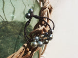 Magnifique bracelet de perles de Tahiti montées sur cuir tressé ajustable en deux longueurs.