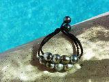 Magnifique bracelet de perles de Tahiti montées sur cuir tressé ajustable en deux longueurs.