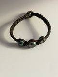 Bracelet quatre perles de Tahiti sur cuir tressé