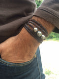 Bracelet pour homme avec quatre belles perles de Tahiti sur cuir australien tressé. Plusieurs tours autour du poignet