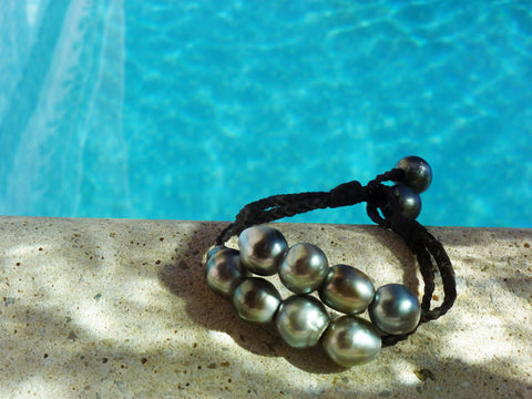 Magnifique bracelet de perles de Tahiti montées sur cuir tressé ajustable en deux longueurs.
